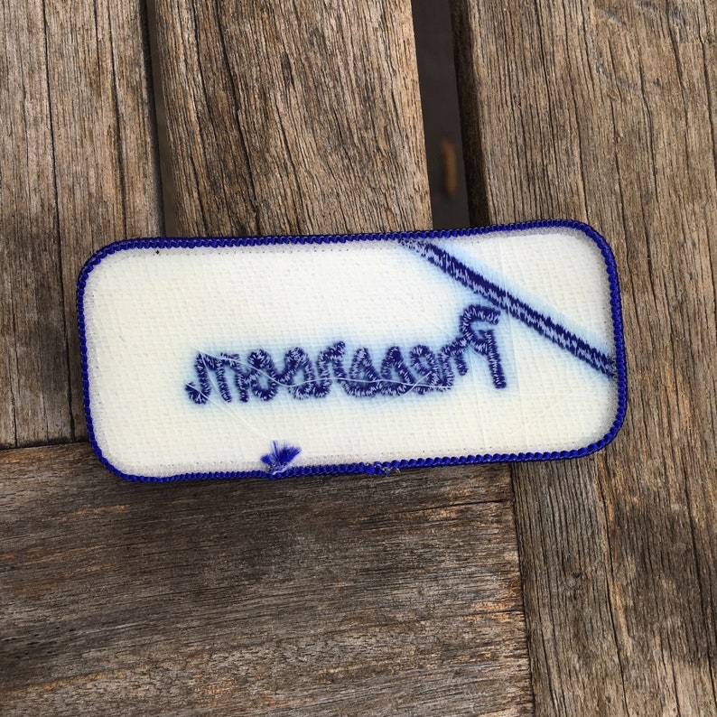 Pressroom A white work shirt uniform patch that says Pressroom in blue script with blue border.