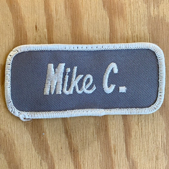 Mike C. A gray patch with "Mike" in white script