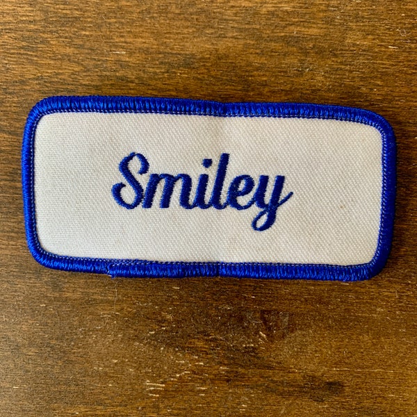 Smiley. A white work shirt patch that says "Smiley" in blue script with blue border