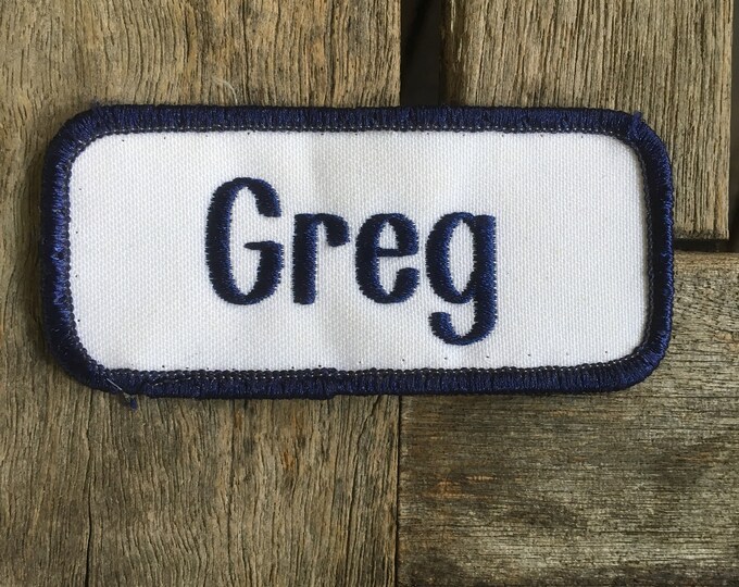 Greg. A White Work Shirt Name Patch That Says greg in Blue Print With