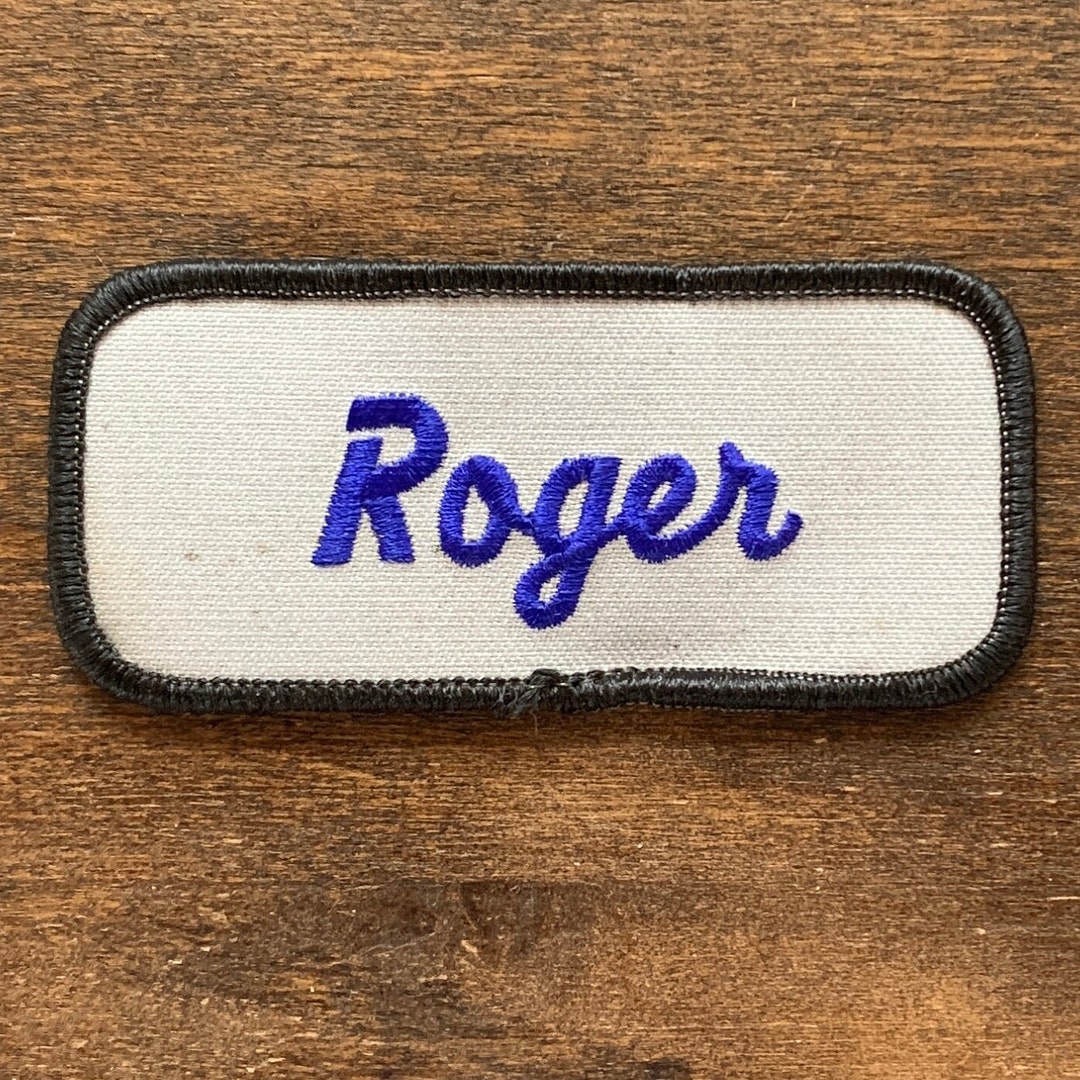 Roger. A White Work Shirt Name Patch That Says roger in Blue Script