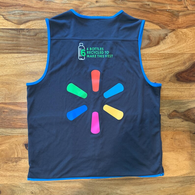 May include: A black sleeveless vest with a blue trim. The vest has a large multi-colored starburst logo on the back. The text '6 bottles recycled to make this vest' is printed above the logo.