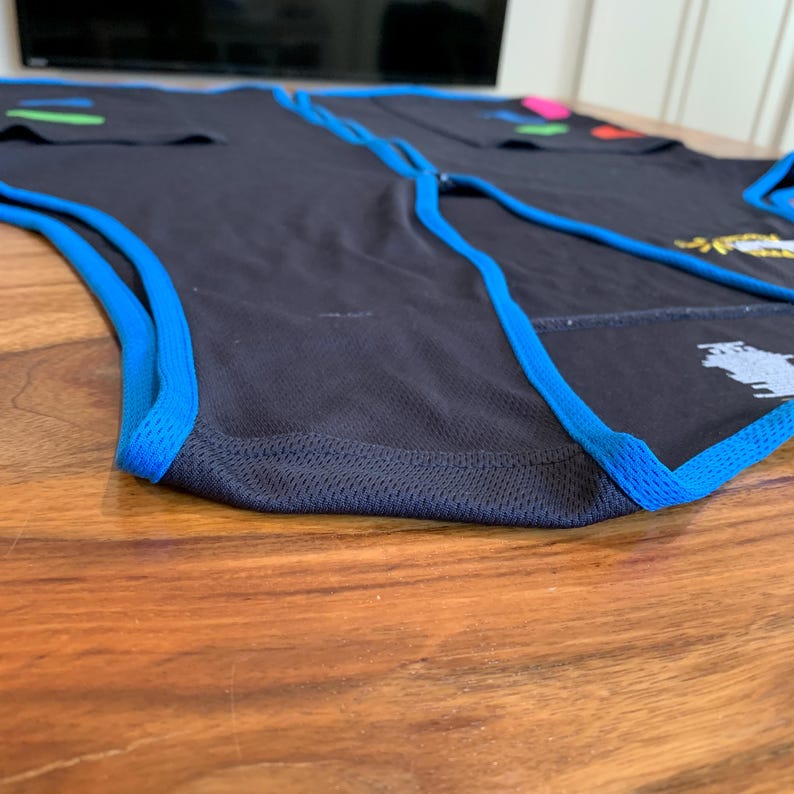 May include: A black sleeveless shirt with blue trim around the armholes and bottom hem. The shirt is made of a breathable, mesh fabric.