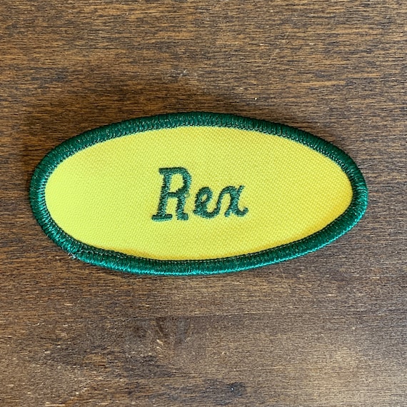 Rex. A white work shirt name patch that says "Rex" in… Gem