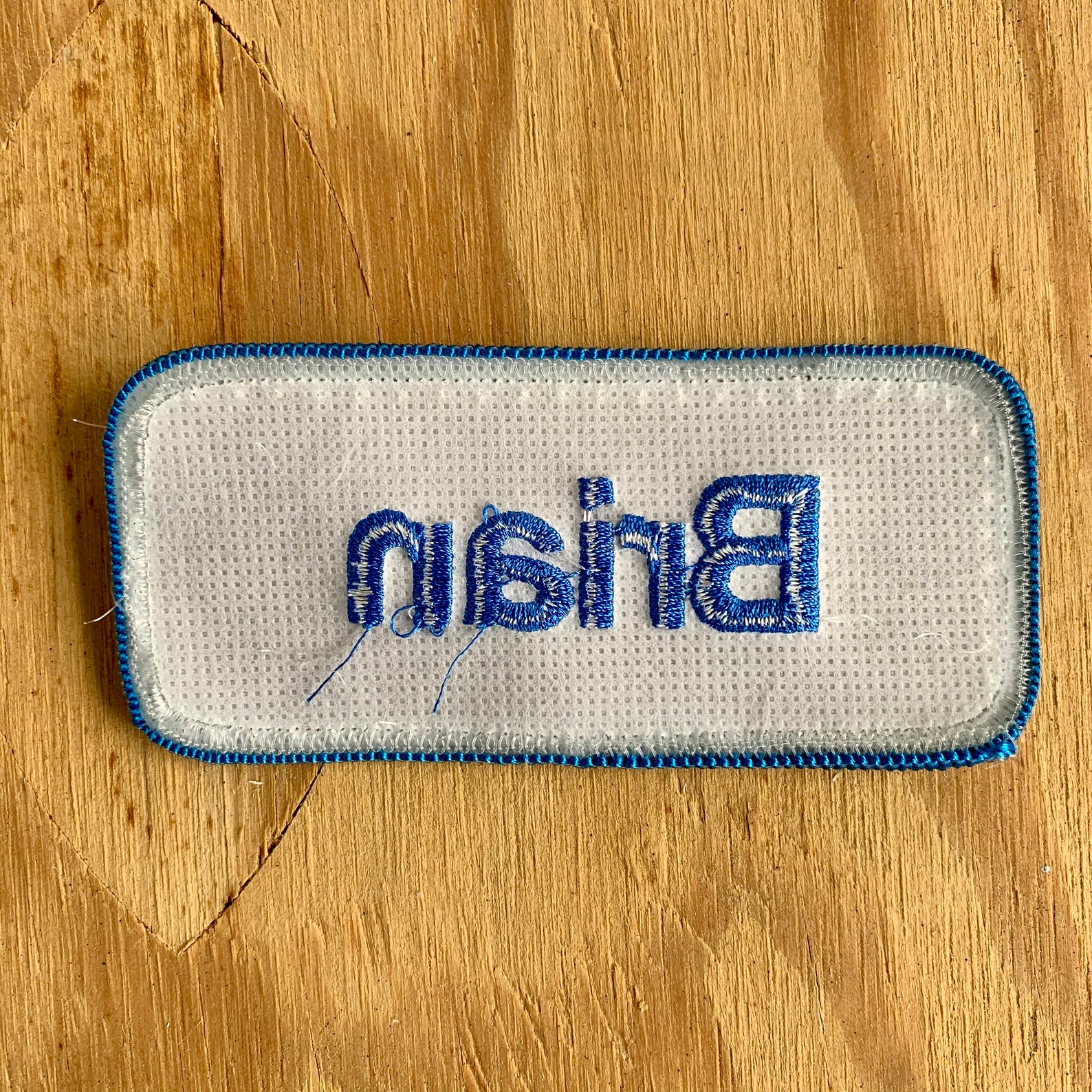 Brian. A gray work shirt name patch that says Etsy