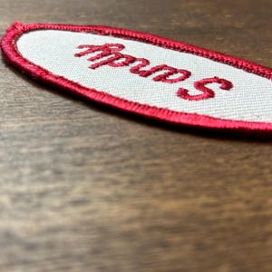 Sandy In Script Sandy A White Work Shirt Name Patch That Says sandy in Red Script With ...