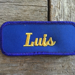 Luis. A royal blue work shirt patch that says Luis in yellow script image 1