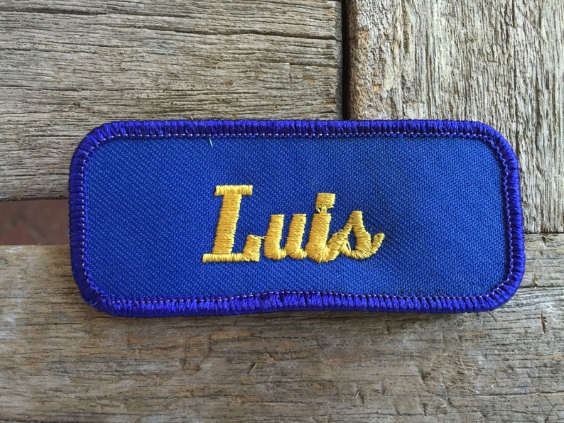 Luis. A royal blue work shirt patch that says Luis in yellow script image 1