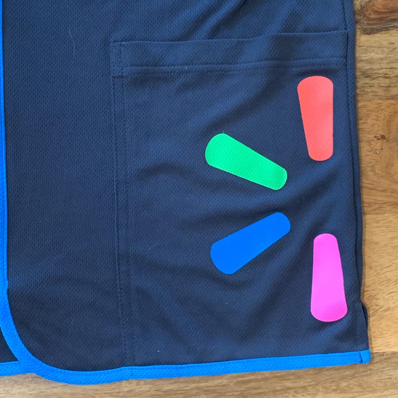 May include: A black work uniform with a blue trim and a blue, green, pink, and red Walmart logo on the pocket.