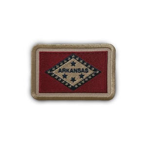 May include: A tan embroidered patch with the state flag of Arkansas. The flag features a red background with a white diamond shape containing a blue star and the word "Arkansas".