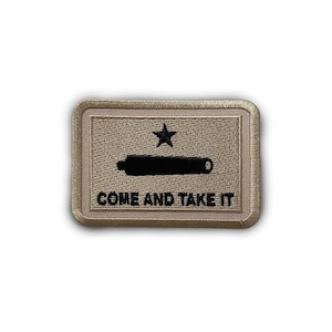 May include: A tan embroidered patch with a black star and cannon, and the text "COME AND TAKE IT".