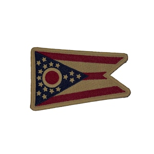 May include: Embroidered patch featuring the flag of Ohio. The patch has a tan background with red stripes and a blue triangle containing white stars and a red circle. The patch is rectangular with a notched end.