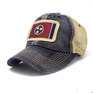 May include: A distressed denim baseball cap with a mesh back. The front features a patch with the Tennessee state flag design in red, white, and blue. The brim is curved, and the stitching is a contrasting tan color.