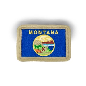 May include: Embroidered patch featuring the state of Montana. The patch has a blue background with the word "MONTANA" in yellow. The state seal is in the center, surrounded by a tan border. The patch is rectangular.