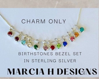 May include: A silver necklace with a charm set of birthstones in bezel settings. The charms are in various colors, including red, blue, green, and pink. The necklace is displayed on a white background with the text "CHARM ONLY", "BIRTHSTONES BEZEL SET IN STERLING SILVER", and "MARCIA H DESIGNS".
