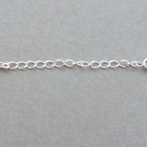 May include: A silver chain necklace with a lobster clasp closure.