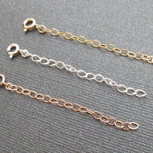 May include: Three chain extenders in gold, silver, and rose gold. Each extender is approximately 5 cm long and has a lobster clasp.