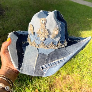 May include: A denim cowboy hat with a patchwork design and embellished with rhinestones and pearls.