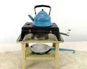 Antique doll cooker stove with tea candle on tin table with enamel dishes