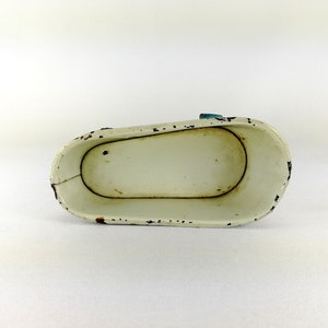 May include: White enamel bathtub toy with blue trim. The bathtub is empty and has a slightly worn finish.