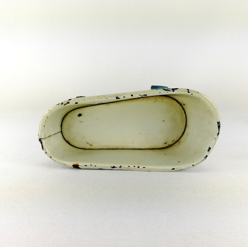 May include: White enamel bathtub toy with blue trim. The bathtub is empty and has a slightly worn finish.