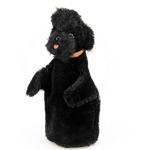 May include: Black plush puppet of a poodle dog with a brown collar. The puppet has a long, fluffy tail and a black nose.