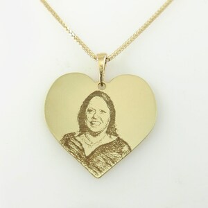 May include: A gold heart-shaped pendant necklace with a photo engraved on the front.