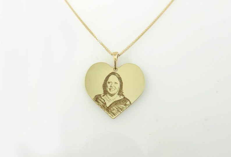 May include: A gold heart-shaped pendant necklace with a photo engraved on the front.