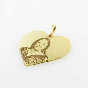 May include: Gold heart-shaped pendant with an engraved image of a person.