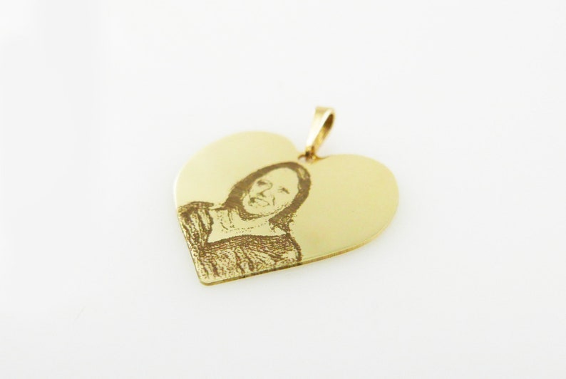 May include: Gold heart-shaped pendant with an engraved image of a person.