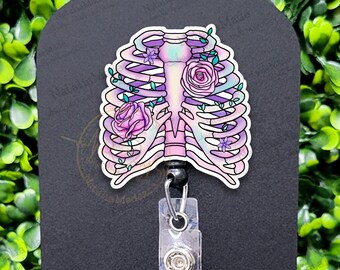 May include: A retractable badge reel with a colorful floral ribcage design. The reel is black with a clear plastic badge holder. The design features pink, purple, and blue flowers.
