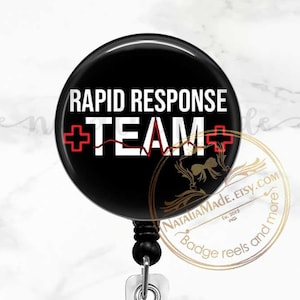 May include: A black and white badge reel with a black round button featuring the text "RAPID RESPONSE +TEAM+" in white with a red heartbeat graphic.