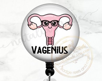 May include: A white badge reel with a clear plastic clip. The badge holder features a cartoon illustration of a uterus with a face, wearing glasses and the text "VAGENIUS".