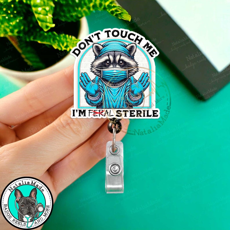 This Funny Retractable Badge Reel is the perfect accessory for surgical techs, sterile processors, OR nurses, surgeons or anyone who works in surgery! Featuring a raccoon donned in surgical gear and the phrase Don't touch me I'm sterile.