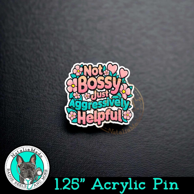 May include: A 1.25 inch acrylic pin with a pink and teal design. The pin features the text "Not Bossy Just Aggressively Helpful" surrounded by pink flowers and hearts.