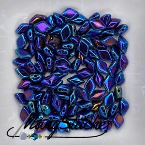 May include: A pile of iridescent blue and purple glass beads in a diamond shape. The beads have a metallic finish and are perfect for jewelry making.