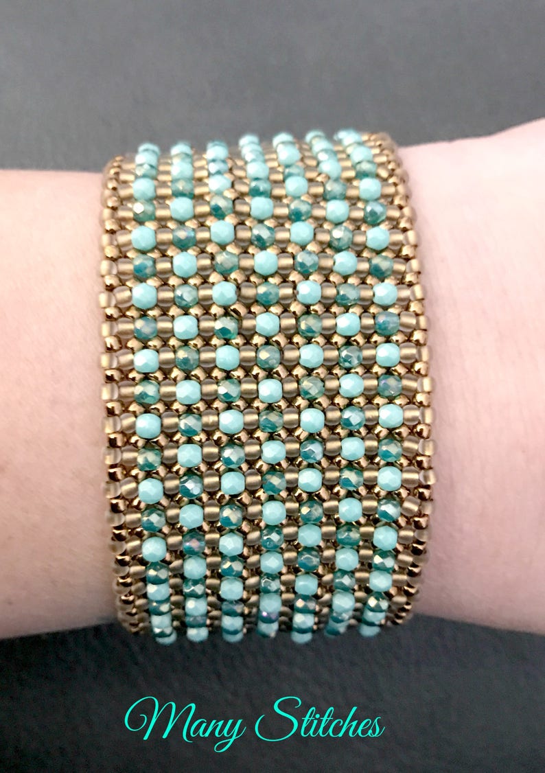 K&ouml;nnte beinhalten: Ein Armband mit abwechselnden Reihen aus goldenen und t&uuml;rkisfarbenen Perlen. Das Armband befindet sich an einem Handgelenk.
