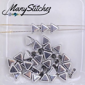 May include: A pile of silver triangle beads, some are strung on a silver wire. The beads are approximately 6mm in size.