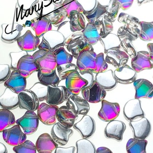 May include: A close-up of iridescent silver and rainbow colored glass beads in the shape of a teardrop. The beads are scattered on a white surface. The text "1118" is visible in the lower right corner of the image.