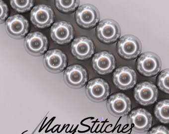 May include: A strand of silver-colored round pearl beads. The beads are arranged in a staggered pattern, with each row slightly offset from the one below it.