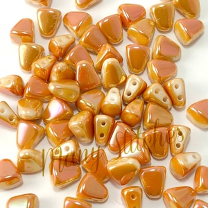 May include: A group of approximately 50 small, iridescent orange triangle-shaped beads. The beads have two holes each and are made of glass.