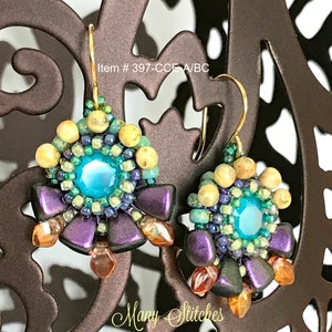 Op de afbeelding: Handgemaakte oorbellen met een centrale turkooizen steen, omringd door groene en blauwe kralen, en accenten in paars en oranje. De oorbellen hebben goudkleurige haken. De tekst "Item # 397-CCE A/BC" is zichtbaar.