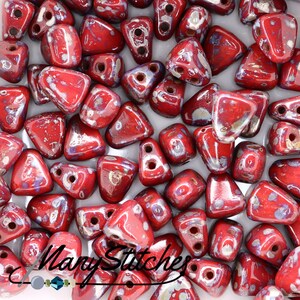 May include: Red and silver triangle-shaped beads with a speckled finish. The beads have two holes each.