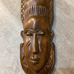 Polynesian handmade wooden mask with carved traditional motifs. Polynesian art. Wooden carved mask.