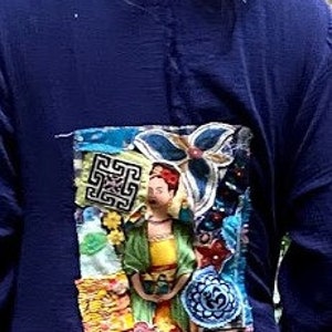 May include: A navy blue long-sleeved shirt with a colorful embroidered patch featuring a person in a yellow dress and a floral design.