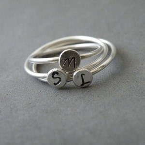 May include: Three silver rings with the letters M, S, and L engraved on them.