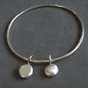 Handgjort armband i sterlingsilver med två berlocker, rustik textur