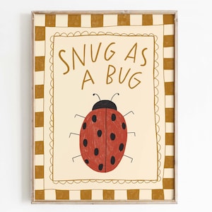 Könnte beinhalten: Gerahmter Kunstdruck mit einer roten Marienkäfer-Illustration und dem Text "SNUG AS A BUG". Der Marienkäfer hat schwarze Punkte und befindet sich auf einem cremefarbenen Hintergrund. Der Rahmen hat ein braun-cremefarbenes Karomuster.
