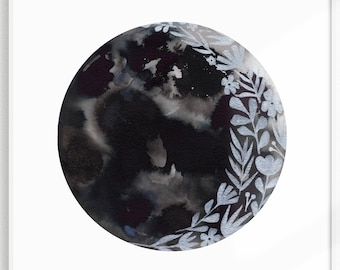 Puede incluir: Una pintura de acuarela en blanco y negro de una luna con un diseño floral plateado alrededor del borde.