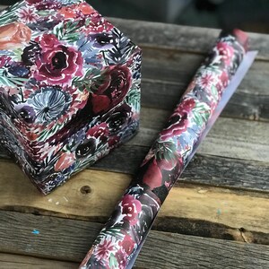Peut inclure: Un rouleau de papier d'emballage &agrave; motif floral avec une bo&icirc;te cadeau assortie. Le papier pr&eacute;sente un motif aquarelle de fleurs rouge fonc&eacute;, rose et bleu sur un fond blanc.